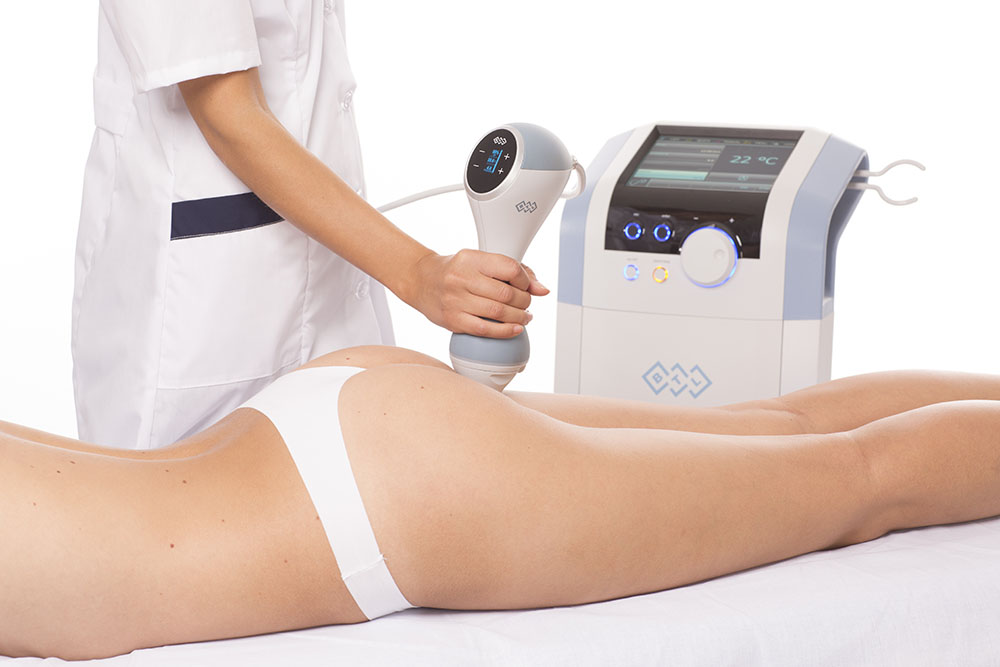 Practitioner treating a woman's thighs with a handheld device at our Harley Street clinic, EMtone cellulite reduction London