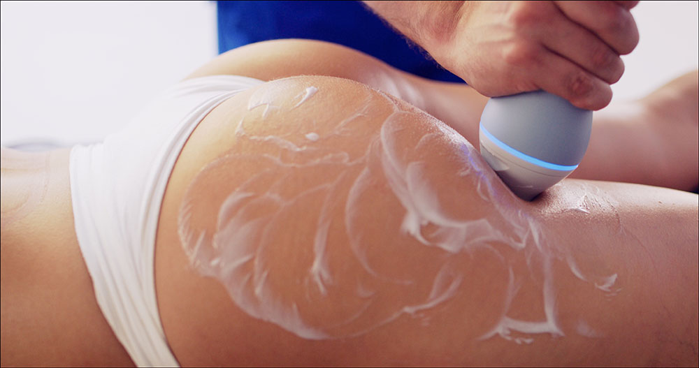 Handheld device treating cellulite on a thigh with gel at our Harley Street clinic, EMtone cellulite reduction London